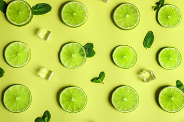 Flat lay composition with fresh juicy limes on yellow background