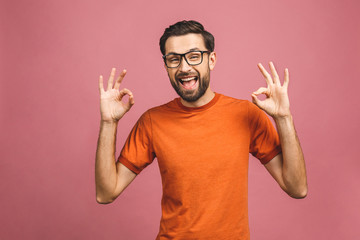 Fototapeta premium A handsome young man in casual isolated on pink background showing ok sign.