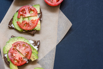 Tomato and Avocado on Toast, on a dark background.