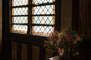 un bouquet de fleur dans une église devant une vieille fenêtre