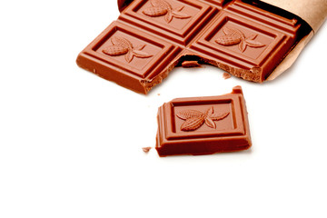 Broken chocolate bar on white table. Horizontal composition. Top view