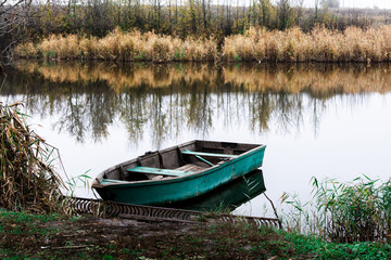 old boat on the lake near the yellowed reeds