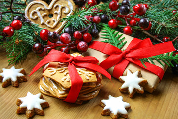 Christmas background with gingerbreads, a gift, spruce branches decorated with red berries