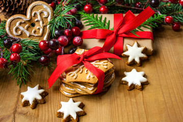 Bożonarodzeniowe tło z pierniczkami, prezentem, gałązkami świerku ozdobionymi czewonymi...