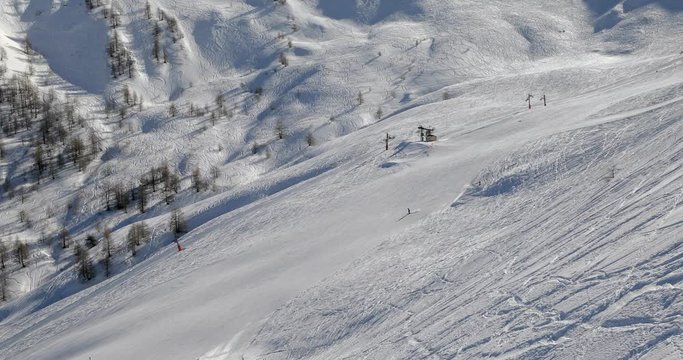 Using ski lift in the Alps, people skiing on the slopes