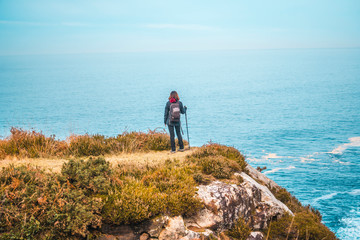 Obraz premium A young woman looking at the sea in a natural viewpoint on Mount Jaizkibel. Basque Country