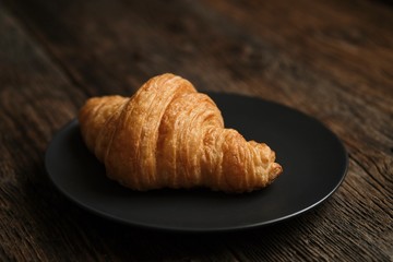 French croissant on the background of a wooden table 