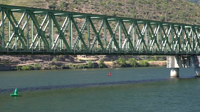 Vineyards line the hillsides as the railway bridge cross the river Douro with just enough headroom for the boat to pass