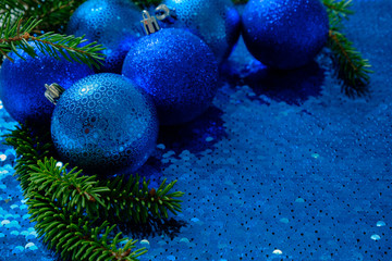 Obraz na płótnie Canvas blue shiny christmas toys / decoration balls on a sparkling blue sequin background. Christmas New Year background with place for text.