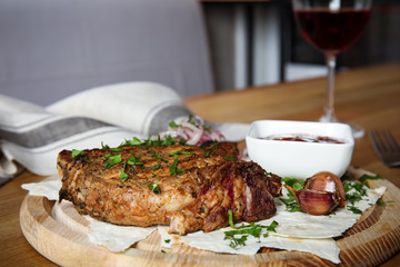 Delicious grilled pork chop served on wooden table indoors
