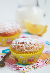 Close-up of two homemade lemon muffins with a jug of milk, selective focus