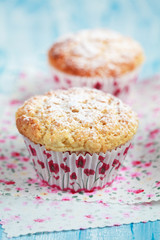 Close-up of two homemade lemon muffins on blue table, selective focus