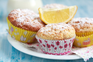 Close-up of homemade lemon muffins with a jug of milk, selective focus