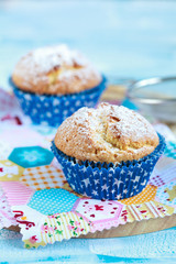 Close-up of two homemade orange muffins with a jug of milk, selective focus