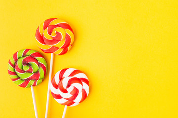 Three colorful Christmas candies on stick. Sweet food for birthday. Lollypop. Copy space. Flat lay