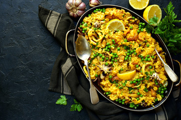 Paella - traditional dish of spanish cuisine in a skillet. Top view with copy space.