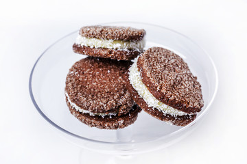dark cookies with tasty white middle filling on a white background