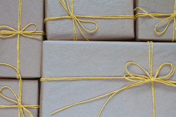 Gift boxes wrapped in recycled paper tied with yellow twine, gift or delivery concept