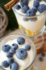 Glasses with blueberry and orange parfait with whipped sour cream. Christmas table, vertical image