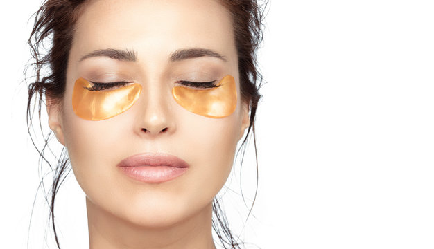 Beautiful woman with clean fresh skin using collagen eye pads under eyes