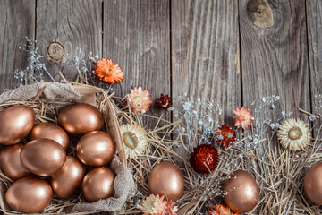 Fototapeta na wymiar Background with Golden Easter eggs on wooden background.