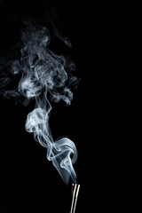 White wispy smoke trails rising up on a black background