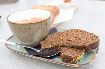 tomato soup with freshly baked bread with modern green gray crockery