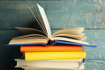 Stack of colorful books on blue wooden background