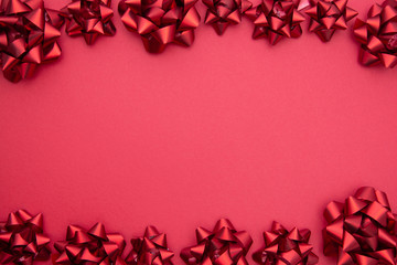 Valentine's Day background. Red ribbon bows over red background, flat lay. Party, birthday, Christmas mock up. Copy space.