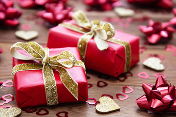 Red gift box with bows, on wooden background. Copy space. Valentine's day, birthday, Christmas.