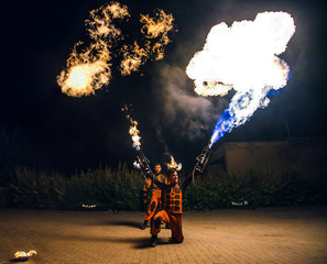 Fire show, dancing with flame, male master fakir with fire works, performance outdoors, flame control man, a man in a suit LED dances with fire, draws a fiery figure in the dark