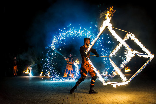 Fire show, dancing with flame, male master fakir with fire works, performance outdoors, flame control man, a man in a suit LED dances with fire, draws a fiery figure in the dark