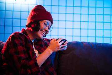 Virtual reality woman gamer in mobile phone, addicted teen. Girl having fun playing online mobile game on her smart phone. © romankosolapov