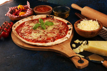 Pizza with tomatoes, mozzarella cheese, basil. Delicious italian pizza on wooden pizza board.