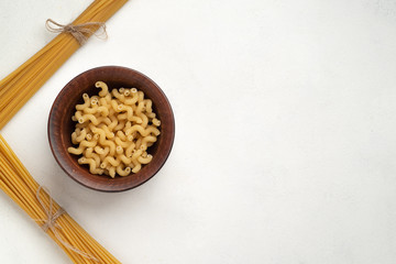 Raw long pasta and plate with swirling pasta. Symmetry. Top view. Free space.