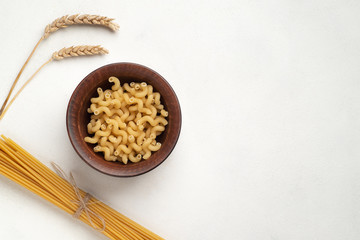 Raw long pasta and plate with swirling pasta. Symmetry and spikelets top view free space