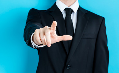 Businessman pointing his finger on a blue background