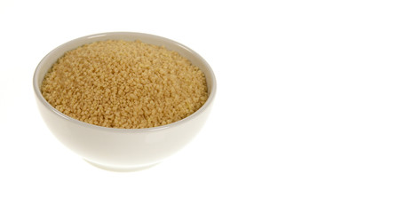 Couscous grains in a bowl isolated on white