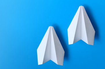 Airplane made of white paper on a blue background.