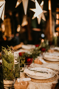 Christmas Table Setting For Traditional Lunch Or Dinner On A Rustic Table With Seasonal Greeting Cards, Tableclothes, Tableware And Festive Decorations. Concept Of Family Traditions And Celebrations