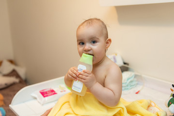 Adorable baby girl sitting under a hooded towel after bath