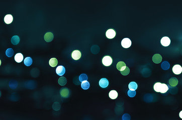 Dark abstract background with blue and green bokeh lights