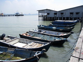 Fototapeta na wymiar Rows of old fishing boats tied up to the pier in George Town, Penang, Malaysia