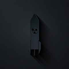 Paper cut Nuclear rocket icon isolated on black background. Rocket bomb flies down. Paper art style. Vector Illustration © vector_v