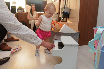 Baby girl 1 year old eating birthday cake in room. Birthday party. Childhood