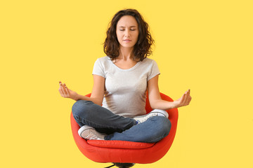 Beautiful woman meditating on color background