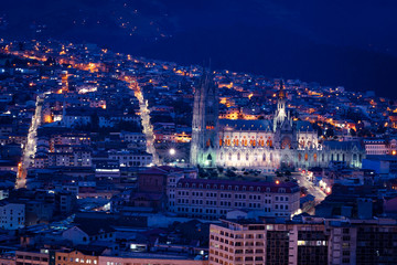 Naklejka premium Quito at night, panoramic view of the old city and the National Basilica in blue tones