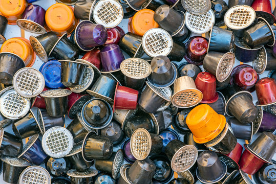 Used coffee capsules of various colors and flavors. These capsules are a problem because they are expensive and difficult to recycle.