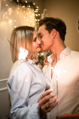 A guy with a girl is celebrating Christmas. A loving couple enjoy each other on New Year's Eve. New Year's love story