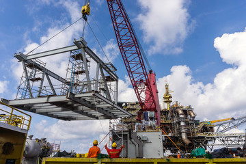 Offshore crane on board a construction work barge performing heavy lifting of a frame strcuture...